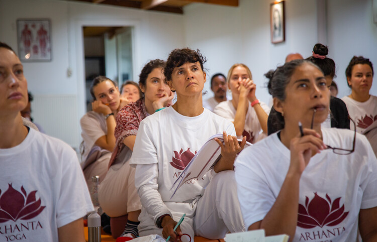 a group of yoga students study anatomy and yoga philosophy at a 200-hour yoga teacher training course hosted by Arhanta Yoga Ashrams in Europe