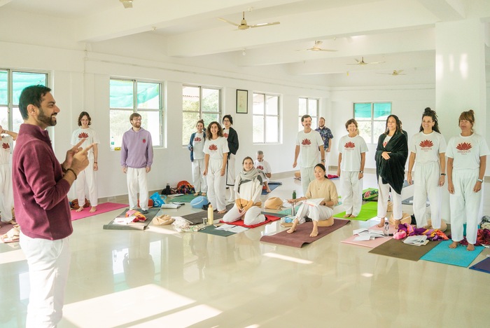 Students enjoying fruitful discussions with expert yoga teacher, showing the benefits of yoga teacher training