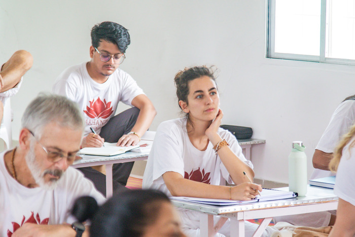 YTT students attending theory class, taking notes; learning yoga beyond poses