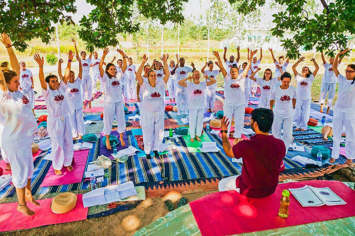Group of yoga students understanding simple yoga movements from yoga teacher training in India