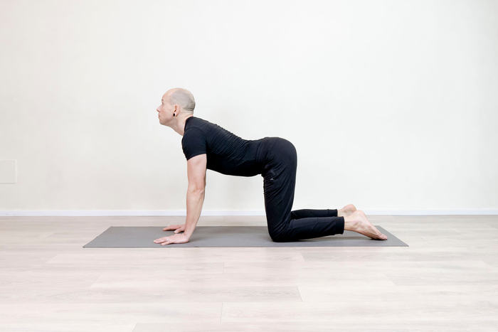 Yoga teacher demonstrating the cat cow pose