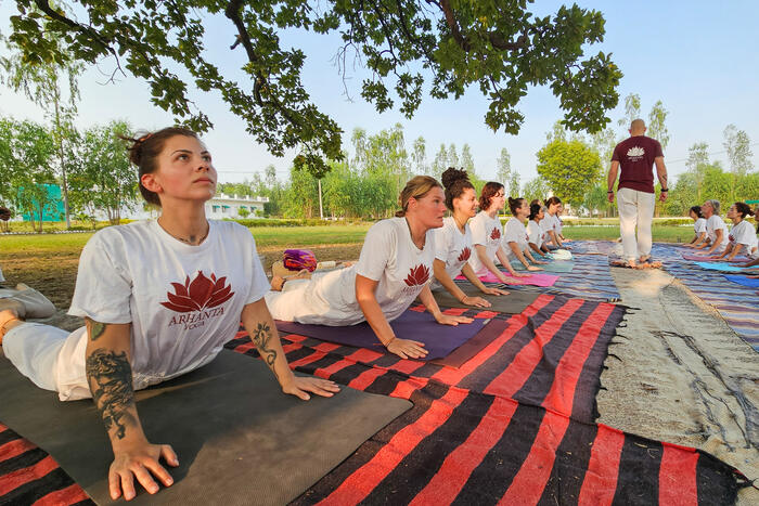 Yoga students practicing the cobra pose on the Ashram ground