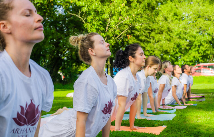 Students practising upward-facing dog outdoors during Vinyasa yoga teacher training