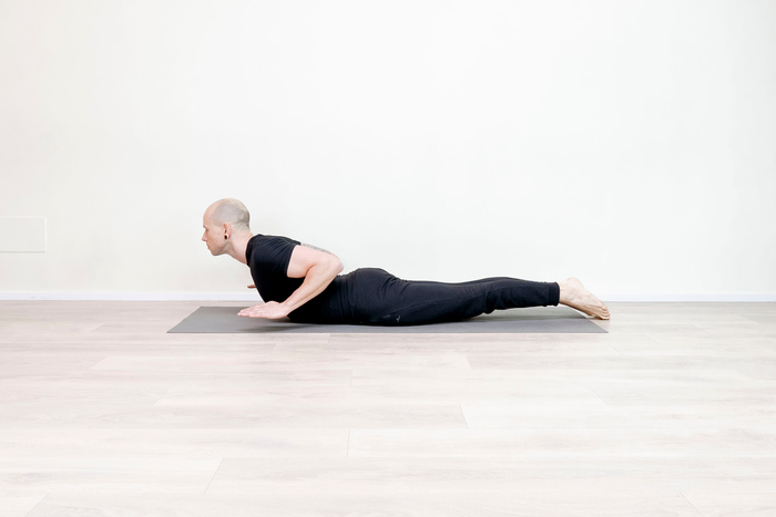 Yoga teacher performing Bhujangasana or Cobra pose